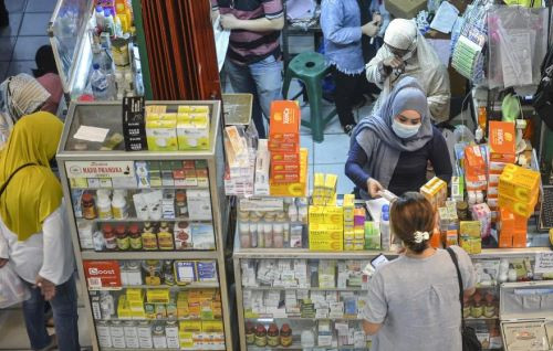 Peddling health: A woman prepares over-the-counter medicines and other health products on July 8, 2021, at a kiosk in Pramuka Market, East Jakarta.