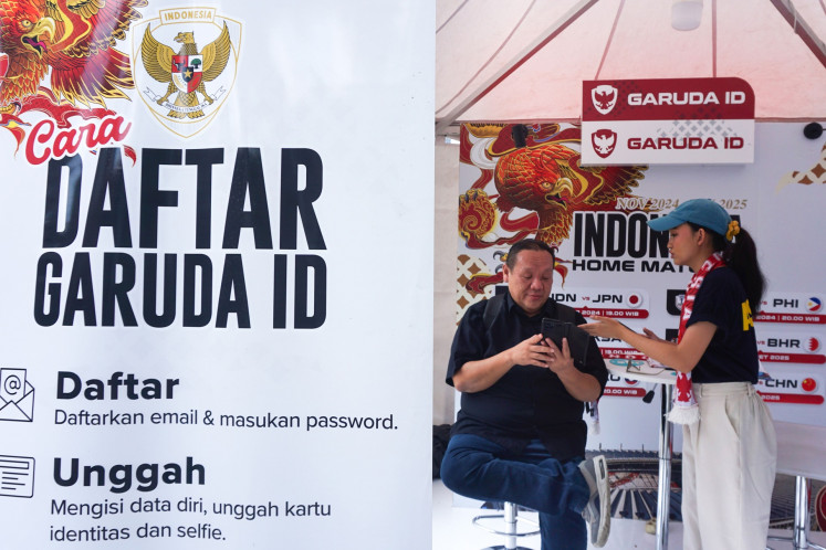 An official helps a user enter his personal data as he signs up for Garuda ID at a booth in Jakarta on Nov. 12, 2024. The system, operated by the Soccer Association of Indonesia (PSSI), is used to buy tickets to Indonesian national soccer team matches, including the Group C match of the 2026 World Cup Asian third-round qualifier against Japan, to be held in Jakarta on Nov. 15. 