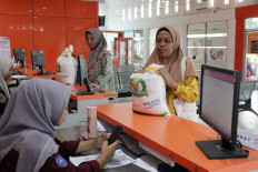 Social aid recipients receive a sack of rice from the government's food reserves distribution program on Oct. 29, 2024, at the Dumai Post Office in Riau. The post office disbursed 10 kilograms of rice to nearly 15,000 families registered as social aid recipients in Dumai in August, October and December 2024.