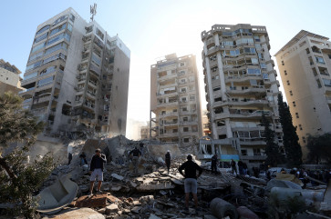 People stand on rubble at a damaged site in the aftermath of an Israeli strike in Tayouneh, amid the ongoing hostilities between Hezbollah and Israeli forces, Lebanon November 15, 2024. 
