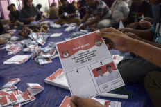 Workers sort and fold ballots for Ciamis regency election at the Ciamis General Elections Commission (KPU) office in West Java on Nov. 8, 2024.