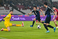 Japanese soccer player Daichi Kamada (right) passes the ball to teammate Koki Ogawa (center) who scores his team's first goal during the 2026 World Cup Asian Group C qualification soccer match between Indonesia and Japan at the Gelora Bung Karno Main Stadium in Jakarta on Nov. 15, 2024.
