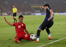Indonesian national soccer team player Pratama Arhan (left) tackles Japanese player Yukinari Sugawara during the 2026 World Cup Asian Group C qualifying match between Indonesia and Japan at Gelora Bung Karno Main Stadium in Jakarta on Nov. 15, 2024.