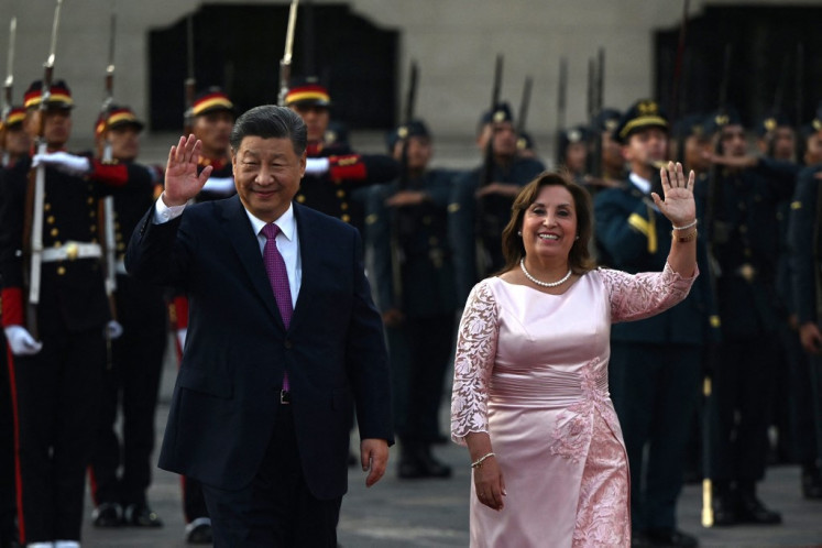 China's President Xi Jinping (left) waves next to Peru's President Dina Boluarte upon his arrival for a meeting at the government palace in Lima on Nov. 14, 2024, on the sidelines of the Asia-Pacific Economic Cooperation (APEC) Summit.