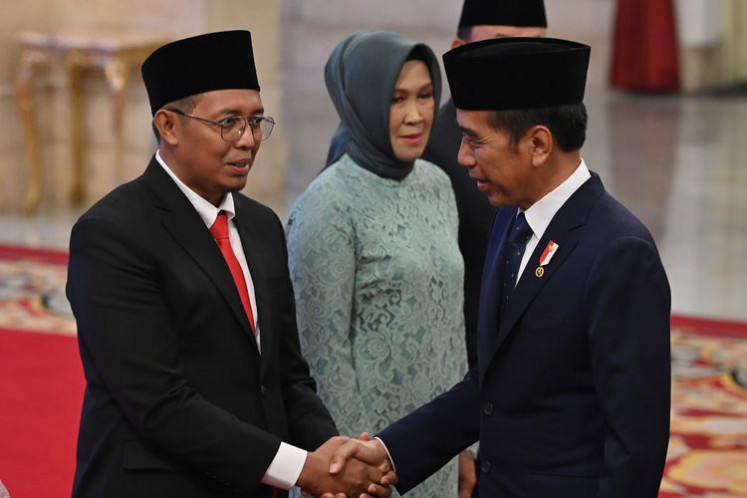 Former President Joko “Jokowi“ Widodo (right) shakes hand with the Presidential Communication Office (PCO) head, Hasan Nasbi, after his swearing-in at the State Palace in Jakarta on Monday, Aug. 19, 2024.