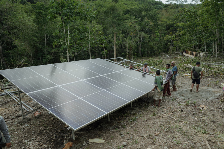 Technicians and residents work together to install solar photovoltaic panels in Naisau village, East Nusa Tenggara, in this file photo from January 2024.