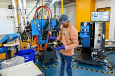 In this photograph taken on September 21, 2024, an employee inspects a freshly stamped vinyl record at Samanvii Digimedia Art and Solutions pressing plant in Navi Mumbai. 