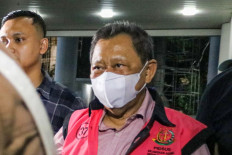 Officers escort businessman Hendry Lie (center) to a detainee vehicle on Nov. 19, 2024, after he was interrogated at the Attorney General's Office (AGO) in Jakarta. Investigators at the Junior Attorney General for Special Crimes detained Hendry as the beneficiary owner of PT Tinido Inter Nusa in an alleged corruption case on a tin trading system within the tin mining concession area of state-owned tin producer PT Timah from 2015 to 2022 that amounted to Rp 332.6 trillion (US$21 billion) in state losses.