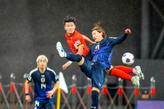 Japan's Ayumu Seko (right) fights for the ball with China's Lin Liangming (center) during the 2026 FIFA World Cup qualification football match between China and Japan in Xiamen, in southeastern China's Fujian province on November 19, 2024. 