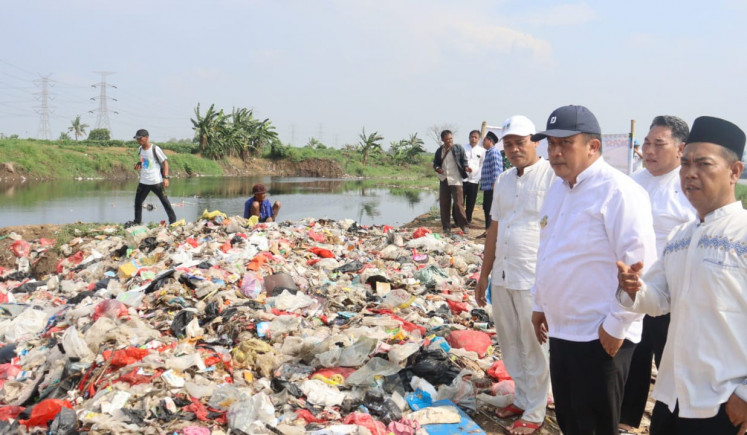 Menunggu penjelasan: Pj Bupati Bekasi Dedy Supriyadi (ketiga kanan) meninjau tumpukan sampah liar sepanjang 200 meter di sepanjang Kali Cikarang Bekasi Laut di Desa Muara Bakti, Kecamatan Babelan, Kabupaten Bekasi, Jawa Barat, 17 November. Pemkab berkomitmen menyelesaikan masalah tersebut dengan menginstruksikan instansi terkait untuk mencari pelakunya, serta menyiapkan anggaran untuk memperluas tempat pembuangan sampah yang ada di kabupaten tersebut.