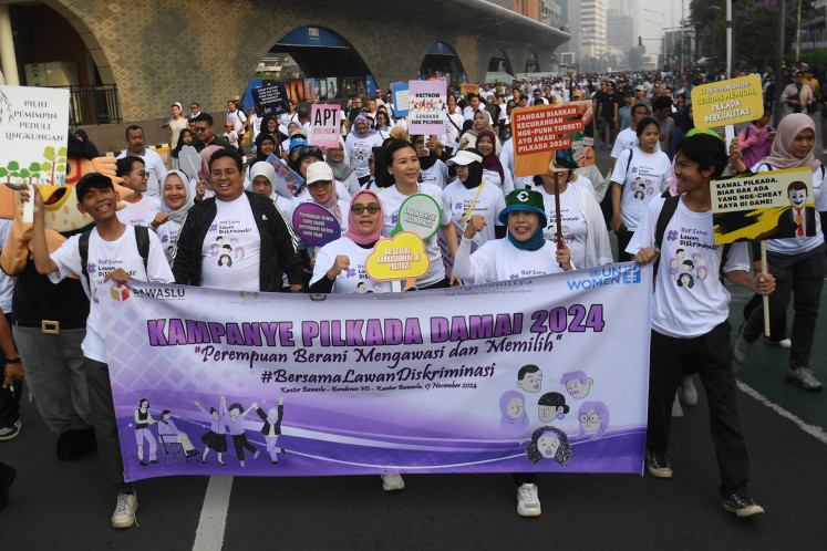 Deputy Women's Empowerment and Children's Protection Minister Veronica Tan (center) and Election Supervisory Agency (Bawaslu) chair Rahmat Bagja (second left) marches with volunteers and officials to campaign for peaceful 2024 simultaneous regional elections in Jakarta on Nov. 17, 2024.