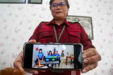 Yogyakarta women's penitentiary head Evy Loliancy shows a recent photo of Filipina death row inmate Mary Jane Veloso (center) playing a keyboard ahead of Christmas celebrations during a press briefing in Wonosari, Yogyakarta, on Nov. 21, 2024. The Philippine woman sentenced to death in Indonesia on drug charges will be handed over to Manila following years of “long and difficult“ negotiations, President Ferdinand “Bongbong“ Marcos Jr said on Nov. 20.