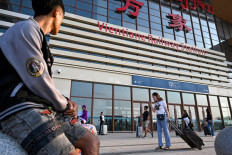 Passengers arrive with their luggage at the railway station in Laos' capital Vientiane on Oct. 12, 2024.