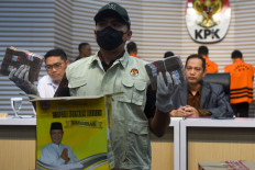 A Corruption Eradication Commission (KPK) investigator shows money seized in a series of arrests in South Kalimantan during a press briefing at the KPK headquarters in Jakarta on Oct. 8, 2024. The antigraft body arrested eight suspects in the operation, including provincial Public Works and Housing Agency official Yulianti Erlynah, and has named South Kalimantan Governor Sahbirin Noor a suspect in the case. 
