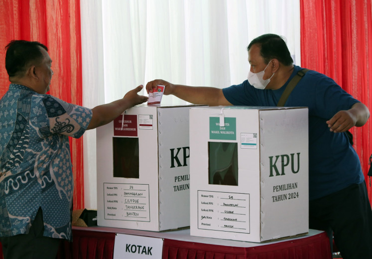 A voter casts his ballot at a polling station in Tangerang, Banten, on Nov. 27, 2024.