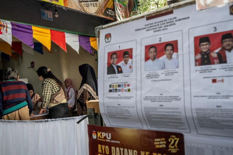 Democracy at work: Workers at a polling station in Jakarta check voters' administrative details on Nov. 27 before people cast their ballots in the 2024 regional head elections, which was conducted simultaneously for the first time across 37 provinces and more than 500 cities and regencies.