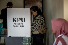 A woman casts her vote in the simultaneous regional elections on Nov. 27, 2024, at a booth in a polling station in Jakarta. Voters in 37 provinces and more than 500 cities and regencies picked regional leaders in the country's biggest simultaneous regional election.