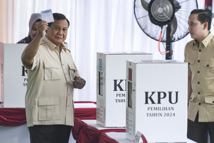 President Prabowo Subianto (left) shows his ballots to journalists after voting in the 2024 simultaneous regional elections at a polling station in Bojong Koneng village, Bogor regency, West Java, on Nov. 27, 2024. The country is holding regional head elections in 37 provinces and more than 500 cities and regencies.