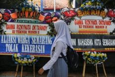 A student walkson Nov. 26, 2024, past flower boards conveying condolences for GRO, a 17-year-old student who died after reportedly being shot by a police officer, at SMKN 4 Semarang state vocational high school in Central Java. The student was reportedly shot when the police officer attempted to disperse an alleged brawl in West Semarang, but the claim has been questioned by members of the public.