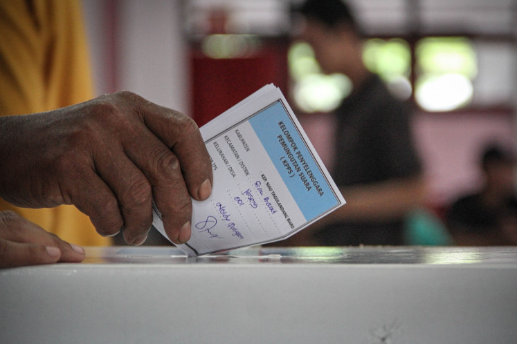 A voter inserts a ballot for the 2024 simultaneous regional elections into a ballot box at a polling station in Sitaro, North Sulawesi, on Nov. 27, 2024. Thirty-seven provinces and more than 500 cities and regencies held simultaneous regional elections on Nov. 27, making it largest one-day regional elections in the country's history.
