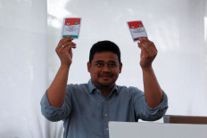 Willing to cooperate: Then-North Sumatra gubernatorial candidate Bobby Nasution holds up ballots ahead of casting his vote for the North Sumatra and Medan elections at a polling station on Nov. 27, 2024, in Medan, North Sumatra.