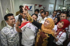 Former East Java governor Khofifah Indar Parawansa (second right), accompanied by former deputy governor Emil Dardak (left), takes a selfie with Perindo Party officials in the party's headquarters in Jakarta on May 22, 2024 after the party declared its early support for the pair in the upcoming East Java gubernatorial election on November. 