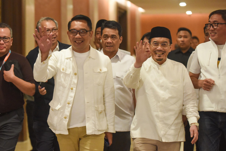 Masih menunggu: Kandidat Gubernur DKI Jakarta Ridwan Kamil (kedua dari kiri) dan pasangannya Suswono (kedua dari kanan) menyapa wartawan menjelang jumpa pers di Jakarta pada 27 November. Pasangan calon tersebut mendesak para pendukungnya untuk menunggu hasil tabulasi suara resmi dari DPR. Komisi Pemilihan Umum (KPU) DKI Jakarta, seraya meminta agar mereka tetap bersemangat jika Pilkada Jakarta dilanjutkan ke putaran kedua.