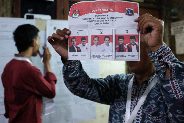 A local poll administrator (KPPS) shows the ballot during the vote counting for the Jakarta gubernatorial election at a polling station in Jakarta on Nov. 27, 2024.