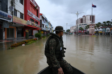 A Malaysian soldier looks out over flood waters in Kota Tinggi, Malaysia's Johor state, on March 4, 2023. 