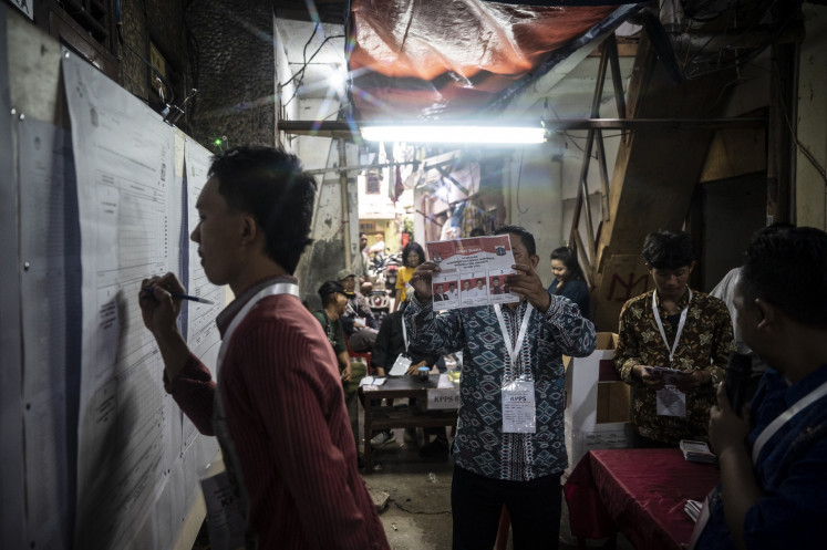 Local poll administrators (KPPS) tabulate votes cast in the Jakarta gubernatorial election on Nov. 27 at a polling station in Tanah Abang, Central Jakarta, during the 2024 regional head elections.