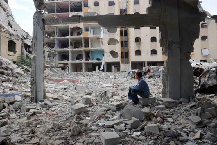A Palestinian boy sits amid the destruction as displaced residents return to Nuseirat in the central Gaza Strip after Israeli shelling of the camp stopped on Nov. 29, 2024, amid the ongoing war in the Palestinian territory between Israel and Hamas.
