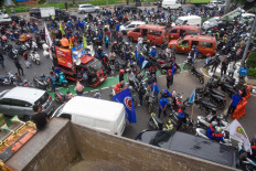 Activists block traffic as they stop other workers from heading to factories during a nationwide strike demanding wage increases at the Cibitung industrial estate in Bekasi regency, West Java, on Nov. 30, 2023