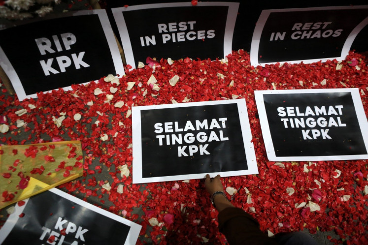 Rest in peace: Employees of the Corruption Eradication Commission (KPK) lay flower petals and signs atop a fake casket in front of the KPK's headquarters in Kuningan, Central Jakarta, in this undated file photo, in a demonstration declaring the “death” of the institution.