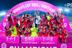 Indonesian women's national soccer team players 0point to the team's head coach Satoru Mochizuki on Dec. 5, 2024, during the trophy awarding ceremony of the 2024 AFF Women's Cup at the New Laos National Stadium in Vientiane. The Indonesian women's national soccer team won the competition after beating Cambodia 3-1 in the final match, qualifying for the 2025 ASEAN Women's Championship.