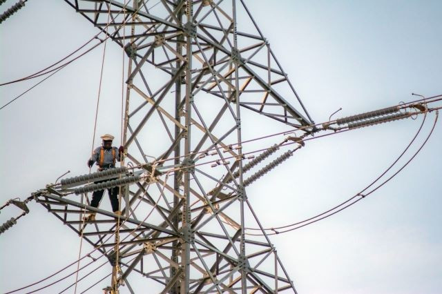 High-risk occupation: A technician from state electricity company PT PLN stands atop a transmission tower during regular maintenance work on Dec. 27, 2023, in Palu, Central Sulawesi. 

