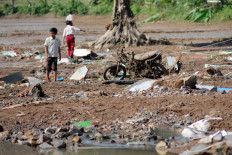 Children play near an area affected by flooding on Dec. 5, 2025, in Sukabumi regency, West Java. Heavy rainfall triggered floods and landslides in several locations across the regency that killed at least five people and left seven missing, according to data from authorities as of Dec. 6.
