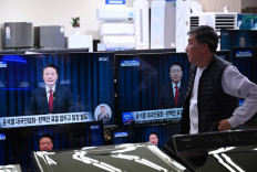 A shopkeeper watches television screens showing a news program reporting an address by South Korea's President Yoon Suk Yeo at an electronic market in Seoul on Dec. 7, 2024. President Yoon apologized for the confusion caused by his declaration of martial law and said he will let his party decide on his future position.