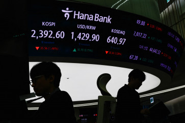 Currency dealers work in front of electronic boards showing the Korean Composite Stock Price Index (KOSPI) and the exchange rate between the U.S. dollar and South Korean won at a dealing room of a bank, in Seoul, South Korea,  on Monday, December 9, 2024. 