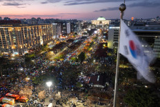 A South Korea flag flutters in the wind as a general view shows people taking part in a protest calling for the ouster of South Korea President Yoon Suk Yeol outside the National Assembly in Seoul on Dec. 7, 2024.