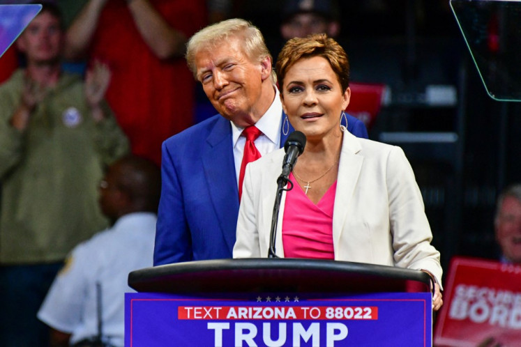 Republican US Senate candidate Kari Lake (right) speaks alongside former US President and Republican presidential candidate Donald Trump during a campaign rally at Findlay Toyota Arena in Prescott Valley, Arizona, on October 13, 2024. 