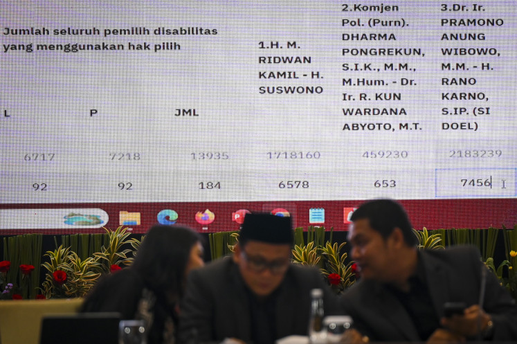 The chair of the Jakarta office of the General Elections Commission (KPU), Wahyu Dinata (right), talks to commissioner Astri Megatari (left) and Irwan Supriyadi Rambe (center) during the Jakarta gubernatorial election's vote tabulation meeting in Jakarta on Dec. 7, 2024.