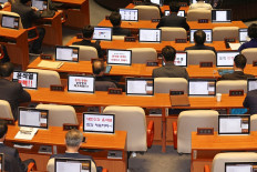 Members of the Democratic Party of Korea display messages calling for the impeachment of South Korea President Yoon Suk Yeol during a National Assembly plenary session in Seoul on Dec. 13, 2024. South Korea's opposition leader warned his ruling party colleagues on Dec. 13 that “history will remember“ if they do not back the impeachment of Yoon, with just over 24 hours until a vote to remove him from office.