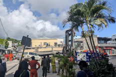 Rescue workers are seen at the site of a collapsed building after a powerful earthquake struck Port Vila, the capital city of Vanuatu, on December 17, 2024. 