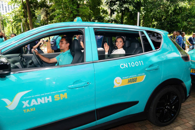 Miss Cosmo 2024 Ketut Permata Juliastrid sits on the passenger seat of Xanh SM EV taxi during the taxi service launch ceremony in Jakarta on Dec. 19, 2024.