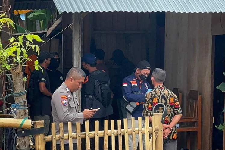 Police officers swarm a house during the arrest of a terrorism suspect on Dec. 19, 2024, in Baiya subdistrict, Palu, Central Sulawesi, after they had been on the run for 11 months.
