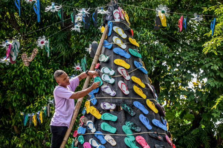 A man decorates a Christmas tree with flip-flops at the Santa Perawan Maria Bunda Christ Catholic Church ahead of the Christmas festival celebrations in Central Java's Klaten on Dec. 20, 2024.