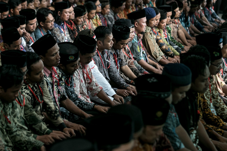 Former members of Jamaah Islamiyah (JI) perform Asr (afternoon) prayers on the sidelines of an event held to declare the disband- ment of the terrorist group at the Convention Hall of the Tirtonadi terminal in Surakarta, Central Java, on Saturday, 21 December, 2024. Some 1,200 for- mer JI members from the greater Surakarta area, as well as 6,800 members from other parts of the country participating in the event online, declared their readiness to rejoin the Unitary State of the Republic of Indonesia. They also expressed their commitment to help safeguard peace and development in the country.