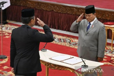Firm salute: Deputy Defense Minister Donny Ermawan Taufanto (left) salutes President Prabowo Subianto before signing a document on his appointment as the National Defense Council secretary at the State Palace on Dec. 12. Prabowo also officiated Defense Minister Sjafrie Sjamsoeddin as the council's executive chairman.