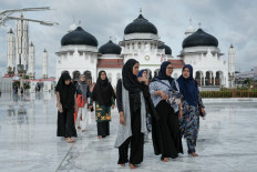 Women walk at the Baiturrahman Grand Mosque in Banda Aceh on December 25, 2024, on the eve of the 20th anniversary of the 2004 Indian Ocean tsunami. 
