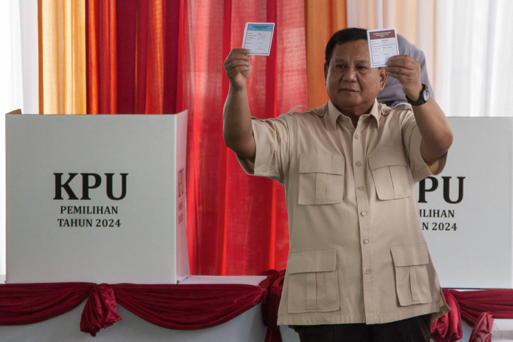 President Prabowo Subianto shows his ballot papers while voting at a simultaneous regional election in Bogor, West Java, on Nov. 27, 2024.